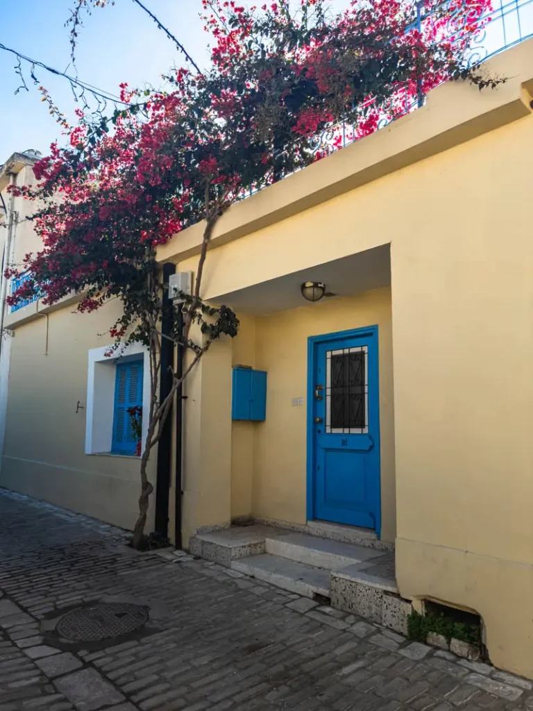 Yellow house with pink flowers over it